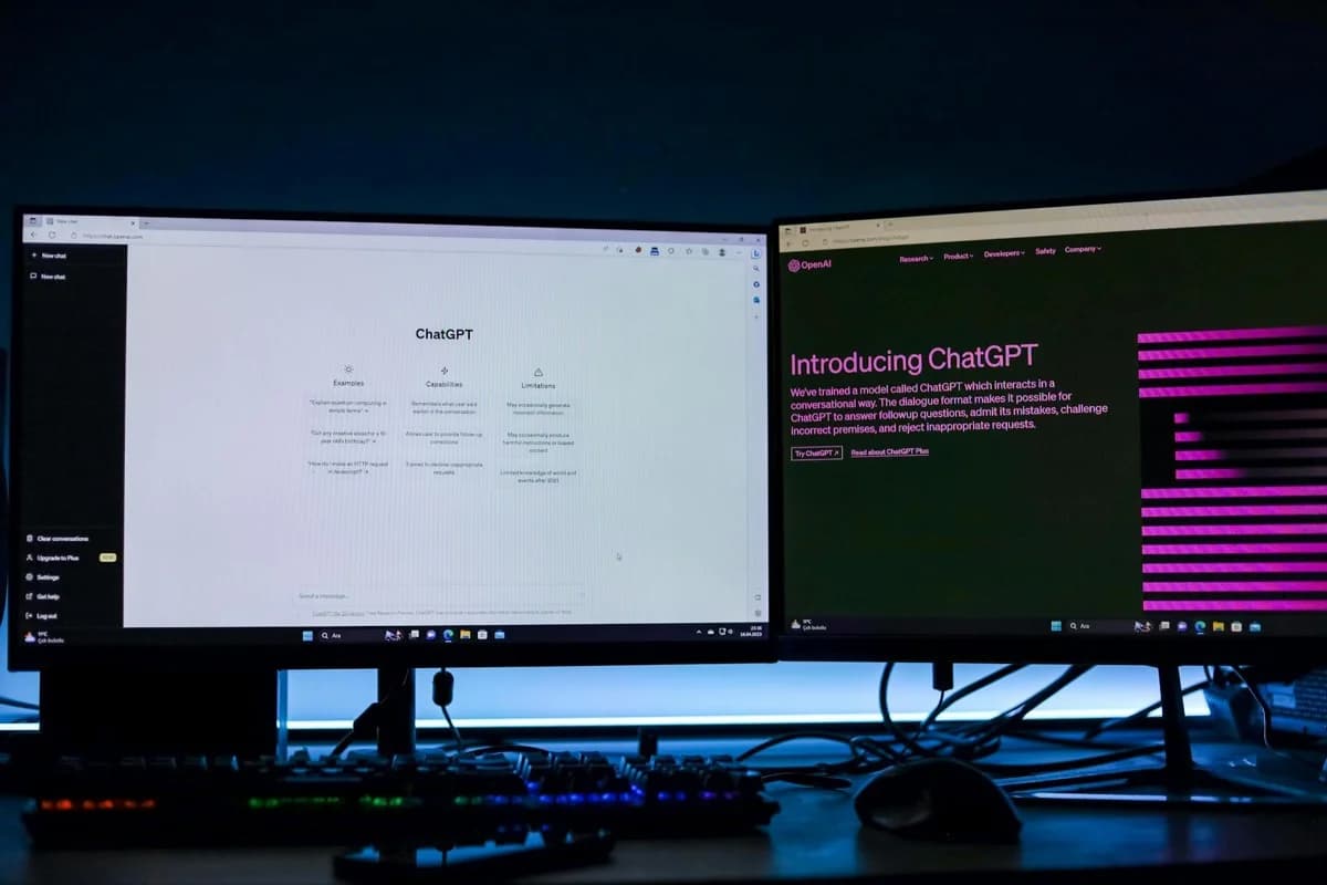Postazione con doppio monitor che mostra interfaccia di chat e piattaforma tecnologica